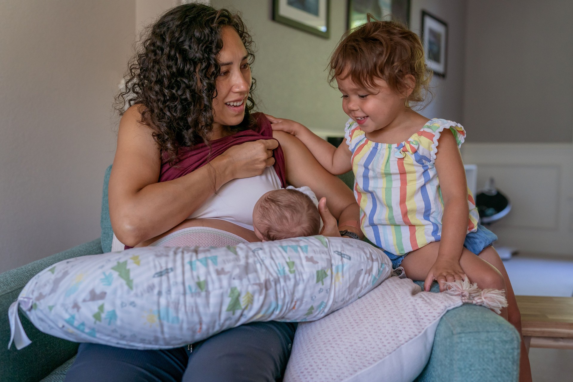 Curious toddler watching her baby brother breastfeed